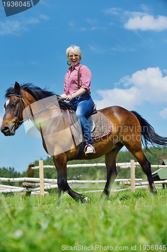 Image of happy woman  on  horse