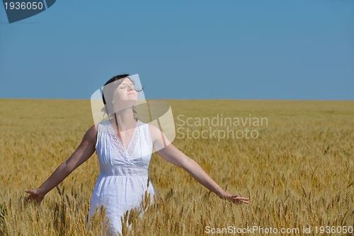 Image of young woman in wheat field at summer