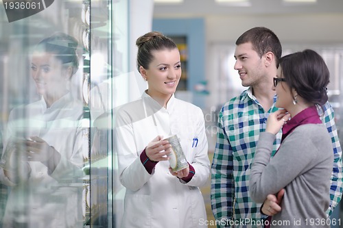 Image of pharmacist suggesting medical drug to buyer in pharmacy drugstor