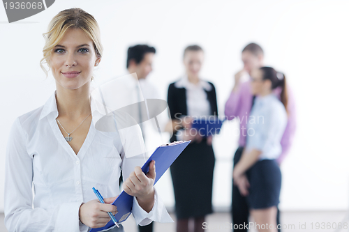 Image of business woman standing with her staff in background