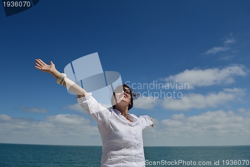Image of young woman with spreading arms to sky