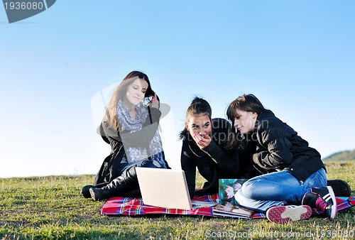 Image of group of teens working on laptop outdoor