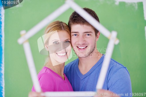 Image of happy couple paint wall at new home