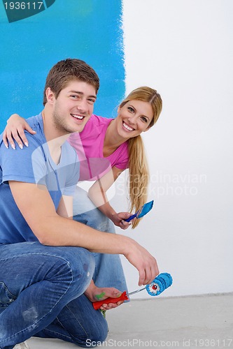 Image of happy couple paint wall at new home