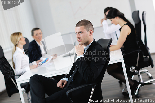 Image of handsome young business man with colleagues in background