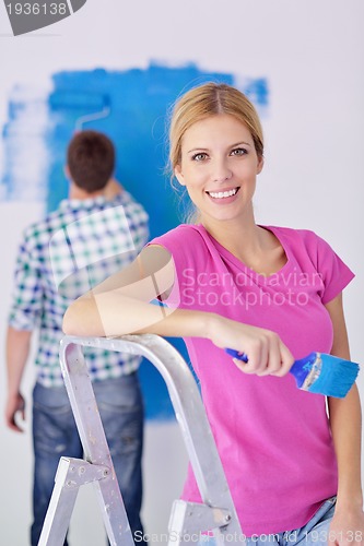 Image of happy couple paint wall at new home