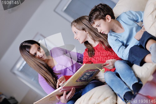 Image of young mom play with their kids at home and reading book