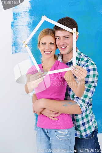 Image of happy couple paint wall at new home