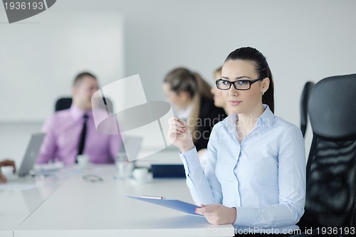 Image of business woman standing with her staff in background