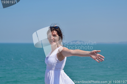 Image of young woman with spreading arms to sky