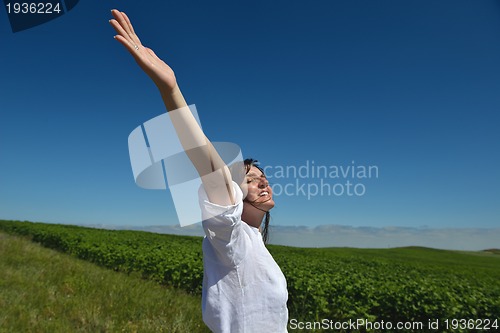Image of Young happy woman in green field