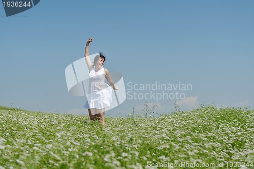 Image of Young happy woman in green field