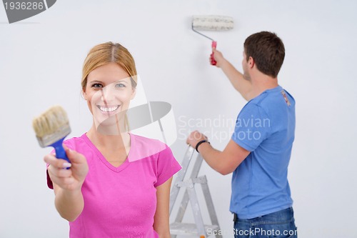 Image of happy couple paint wall at new home