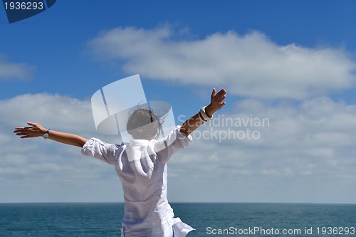 Image of happy young woman with spreading arms to sky