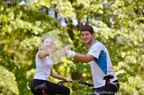 Image of Happy couple ridine bicycle outdoors