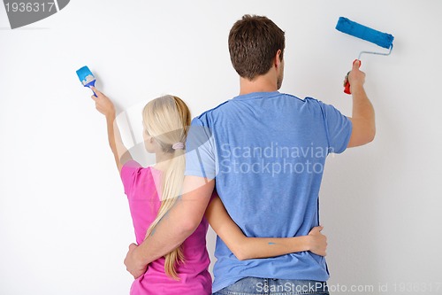 Image of happy couple paint wall at new home