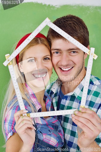 Image of happy couple paint wall at new home