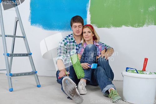 Image of happy young cople relaxing after painting in new home