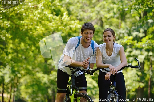 Image of Happy couple ridine bicycle outdoors