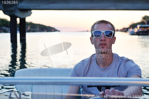 Image of portrait of happy young man on boat