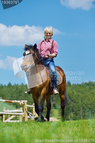 Image of happy woman  on  horse