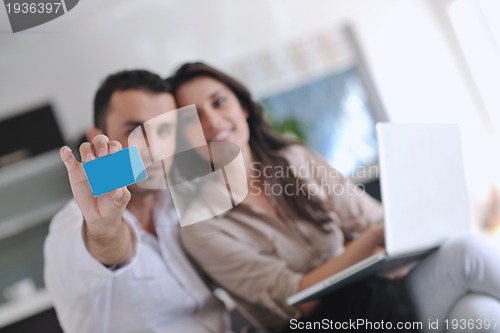 Image of joyful couple relax and work on laptop computer at modern home