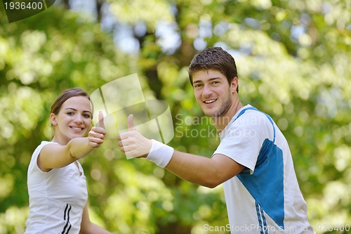 Image of Happy couple riding bicycle outdoors