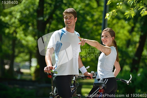 Image of Happy couple ridine bicycle outdoors