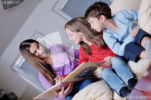Image of young mom play with their kids at home and reading book