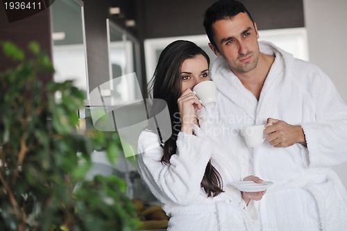 Image of Young love couple taking fresh morning cup of coffee