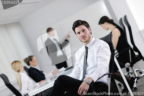 Image of Portrait of a handsome young business man with colleagues in bac