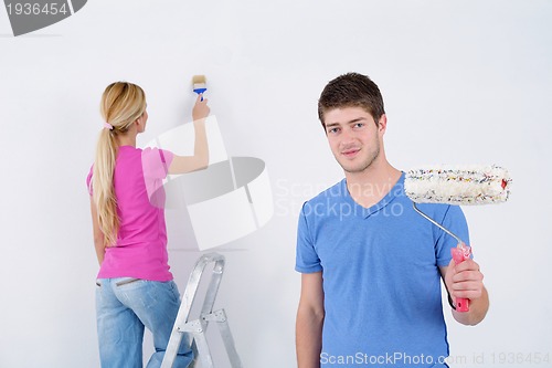 Image of happy couple paint wall at new home