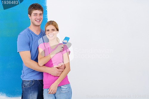 Image of happy couple paint wall at new home