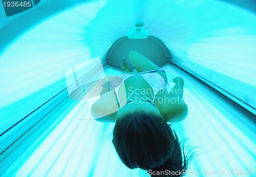 Image of Beautiful young woman tanning in solarium