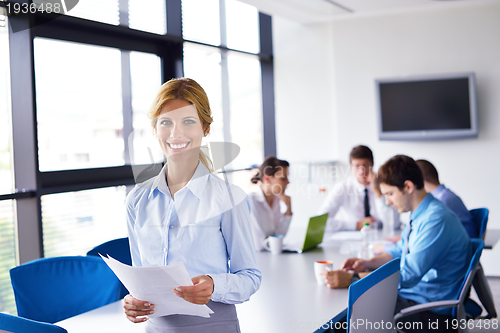 Image of business woman with her staff in background at office