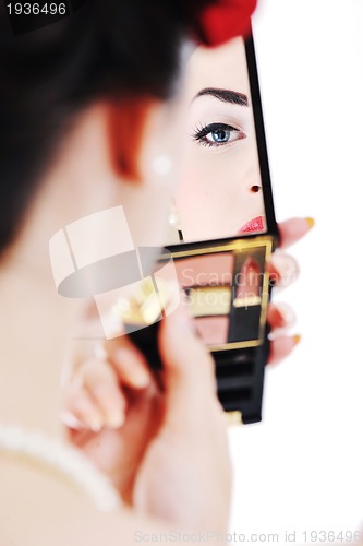 Image of beautiful young woman applying makeup