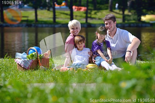 Image of Happy family playing together in a picnic outdoors