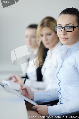 Image of business woman standing with her staff in background