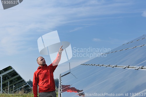 Image of engineer using laptop at solar panels plant field