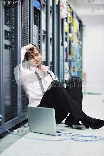 Image of businessman with laptop in network server room