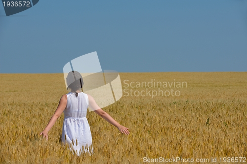Image of young woman in wheat field at summer