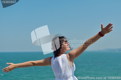Image of happy young woman with spreading arms to sky
