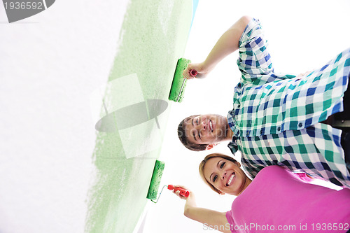 Image of happy couple paint wall at new home