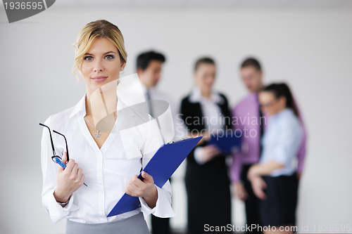 Image of business woman standing with her staff in background