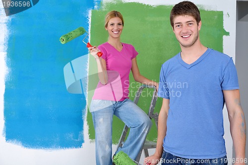 Image of happy couple paint wall at new home