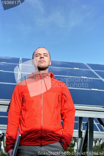 Image of engineer using laptop at solar panels plant field