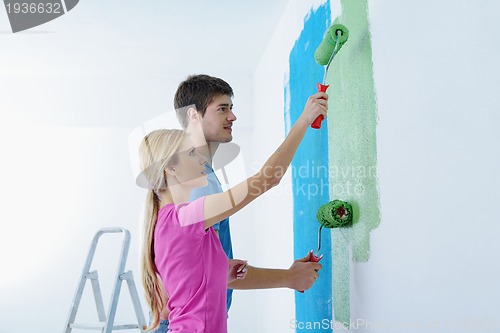 Image of happy couple paint wall at new home