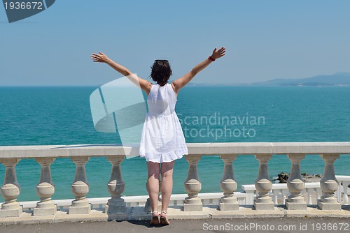 Image of happy young woman with spreading arms to sky