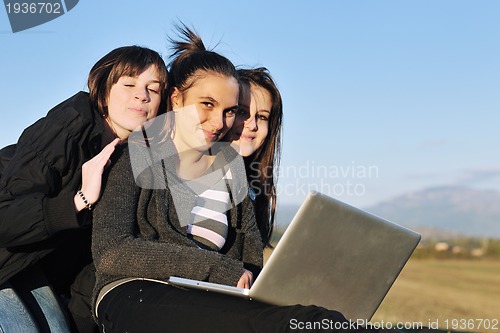 Image of group of teens working on laptop outdoor