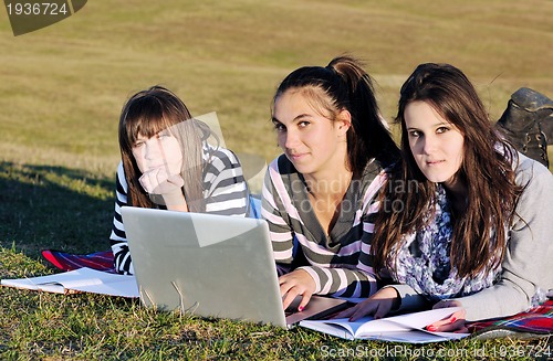 Image of group of teens working on laptop outdoor